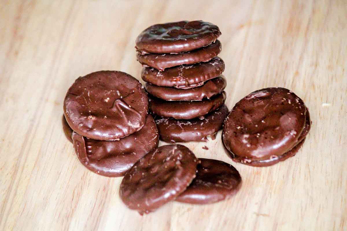 A stack of thin mint cookies on a cutting board