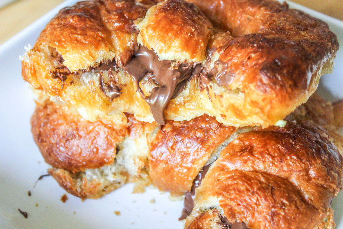A close up of two nutella stuffed croissants stacked on top of each other